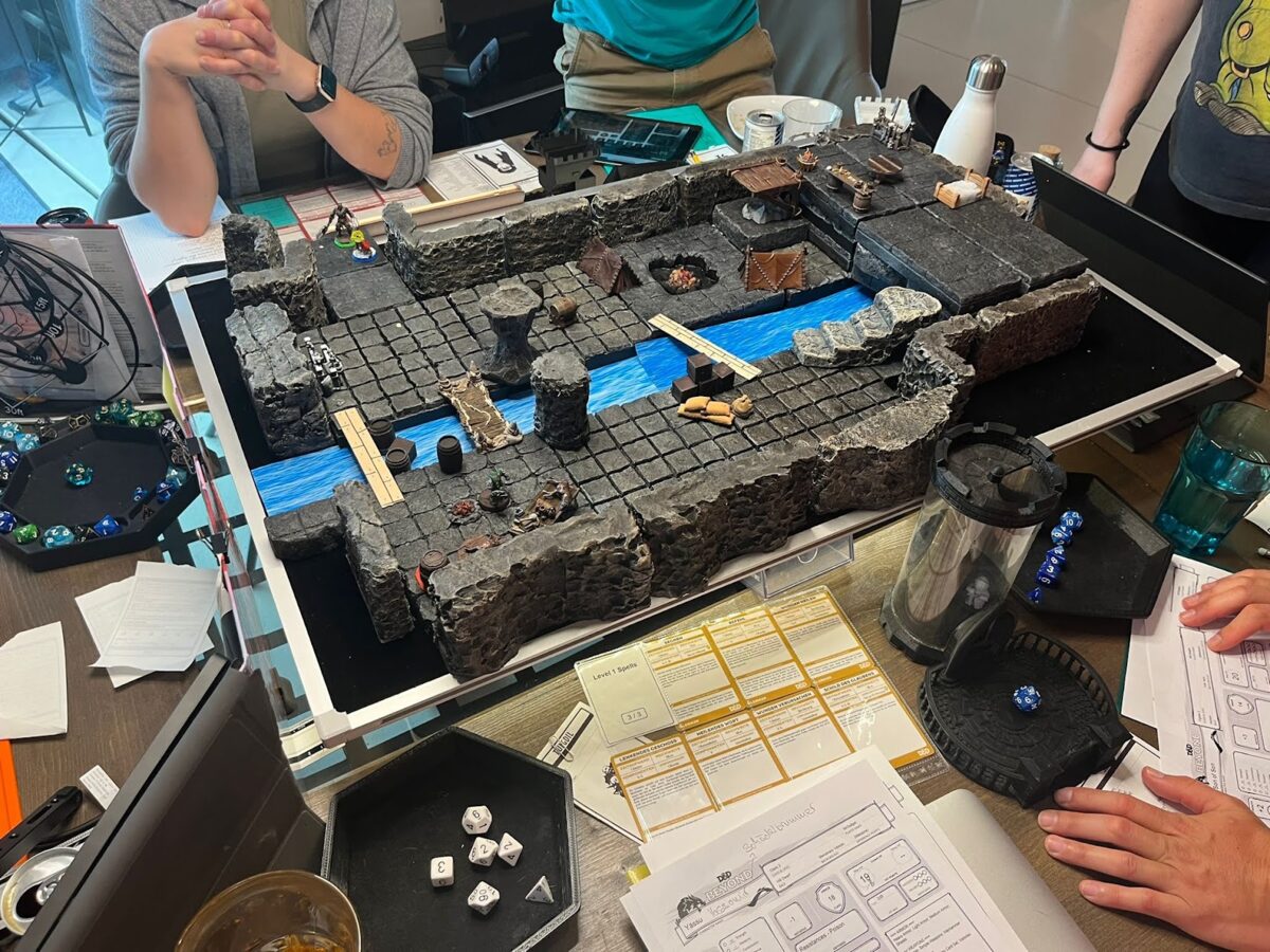 Kleine Gruppe beim Tabletop-Rollenspiel mit Würfeln und Charakterbögen